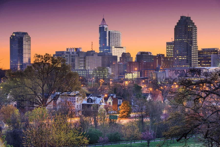 Downtown Raleigh skyline with city lights and beautiful orange sunset